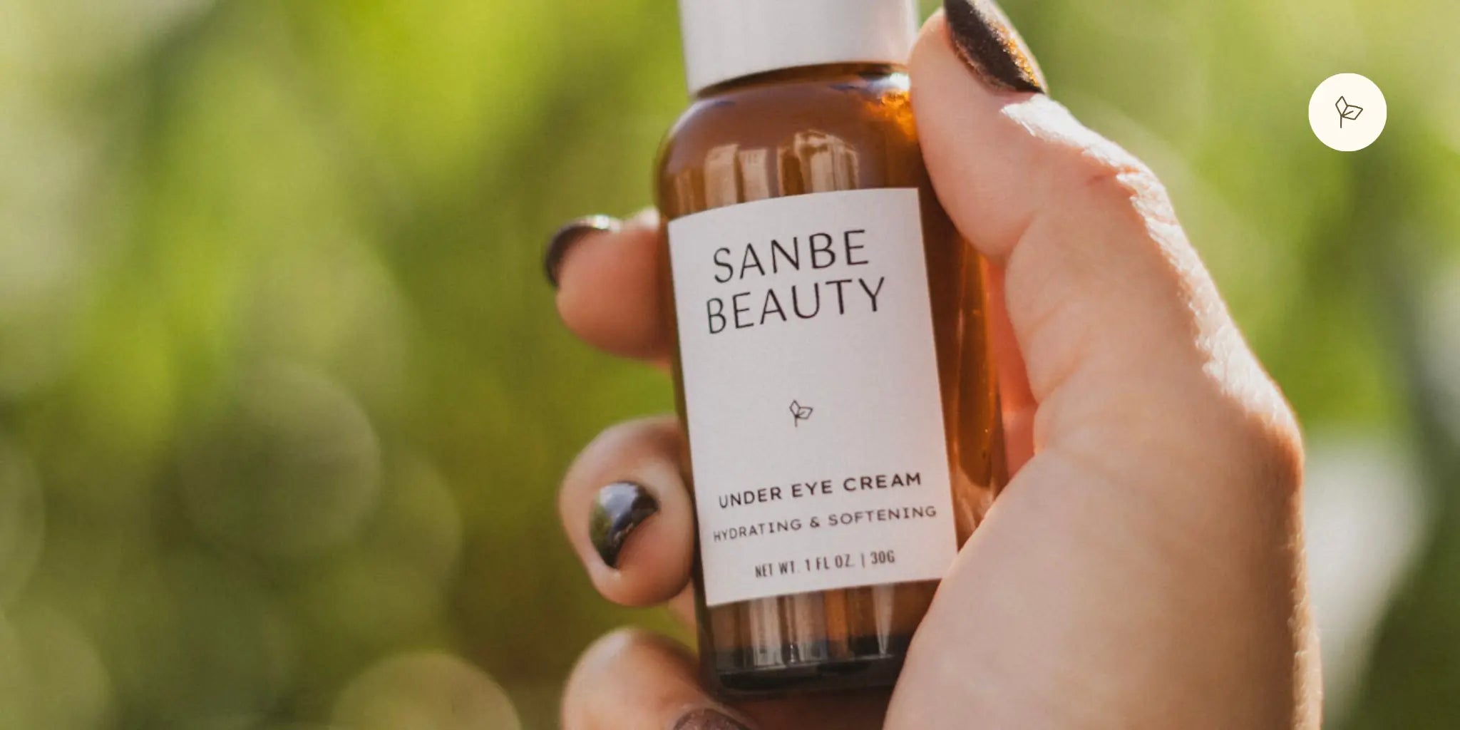 Hand holding Sanbe Beauty organic under eye cream for dark circles and mature skin