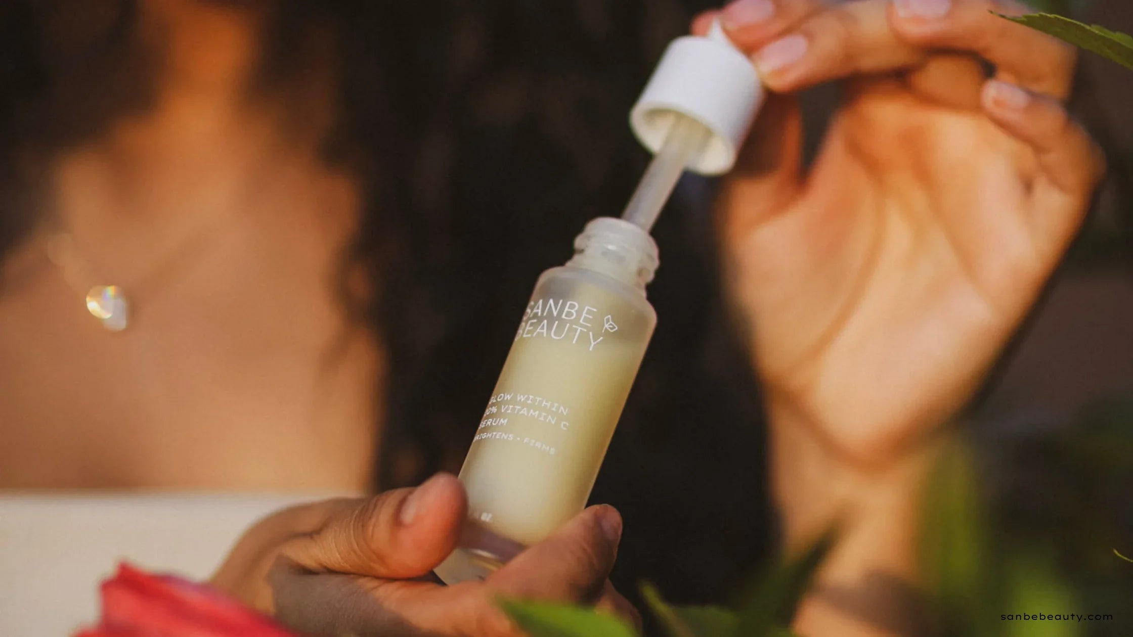 Woman holding Sanbe Beauty Vitamin C Serum with dropper